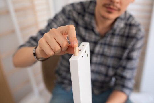 Man assembling kit furniture at home