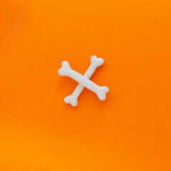 Bones lie on orange background. Happy Halloween, design element