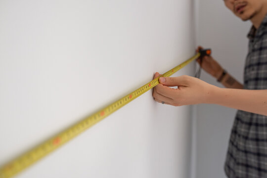 Man measuring wall 