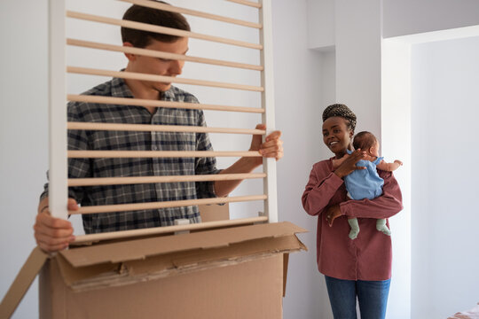 Father unpacking baby crib