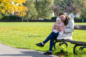 Mother and Baby Enjoying Autumn Day in the Park