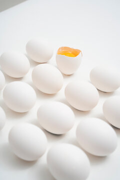 Whole and Cracked Eggs on White Background