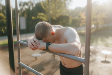 Obraz premium Young Man with Muscular Naked Torso Resting After Outdoor Training