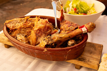 Fuente de barro con cordero lechal asado al horno de leña.