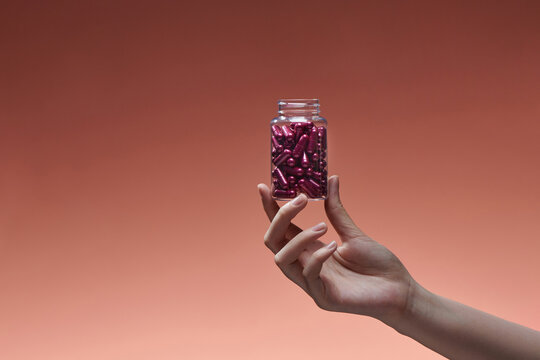 Female hand opening pills bottle. 
