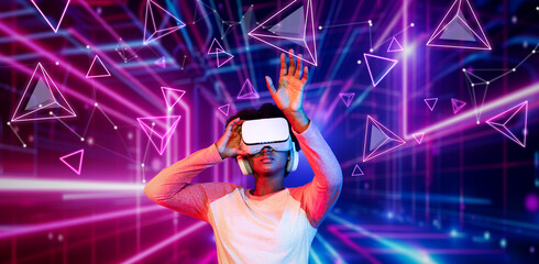 Girl looking around at geometric shape floating in metaverse. Happy teenager or gamer using VR headset and augmented reality technology accessing virtual world. Technology innovation. Ingenuity.