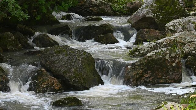 Aigir stream in Ural mountains. Flowing water cascades down over rocks and stones
