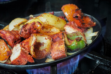 Grilled vegetables and marinated meat, garnished with spices and herbs The colorful array includes chunks of bell peppers, onions, and juicy pieces of meat.