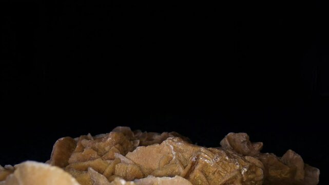 A desert rose is an rose-like formation of crystal clusters of gypsum or baryte, which include abundant sand grains - macro, close-up video clip of its surface. 