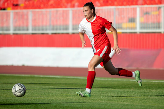 Woman Soccer Player Dribbling at Stadium