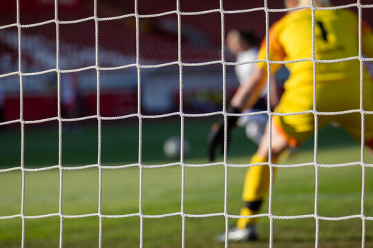 View Through Football Goal Net During A Game