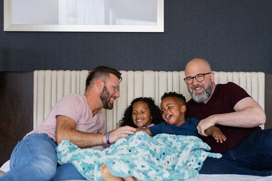 Happy Family Laughing and Bonding on the Bed