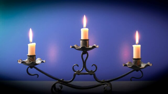 Drei kleine Kerzen verbrennen im schmiedeeisernen Kerzenst&auml;nder. 5 Stunden in 13 Sekunden Zeitrafferdarstellung.