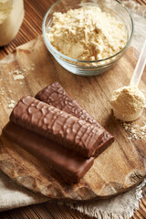 Healthy vegetarian protein chocolate bars with a bowl of whey protein powder