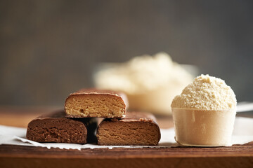 Healthy vegetarian protein chocolate bars with a scoop of whey protein powder