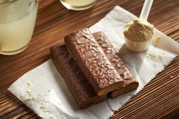 Three healthy vegetarian protein chocolate bars with whey protein powder and drink