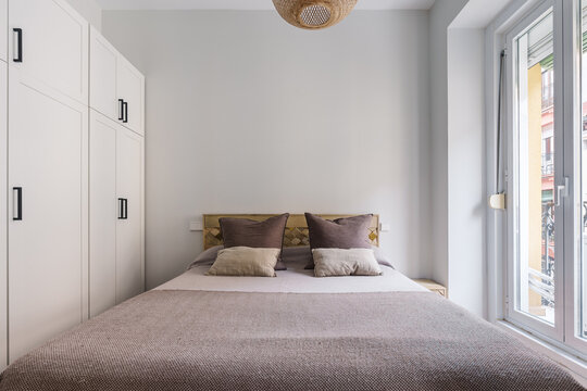 A small bedroom with a neatly made bed