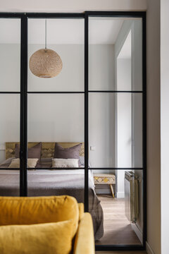 Modern bedroom with a cozy vibe featuring a large glass partition