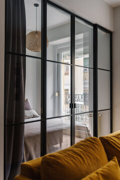 A cozy bedroom with a glass partition and black metal frames