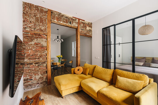 A modern living room with an exposed brick wall