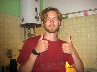 UGC Young Man in a Retro Kitchen Giving Thumbs Up