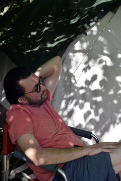 Man relaxing at camping in a shadow