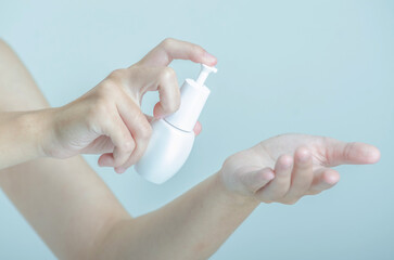 Hands Applying Skincare Product with Pump Bottle