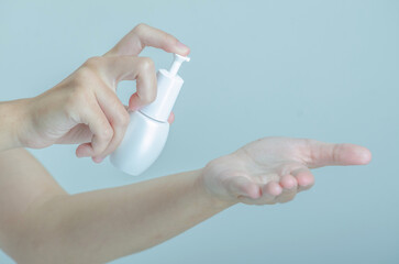 Hands Applying Skincare Product with Pump Bottle