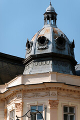 A close-up of a historic building showcases its distinctive dome, adorned with intricate details.  However, a section of the roof is in urgent need of repair, revealing signs of neglect.