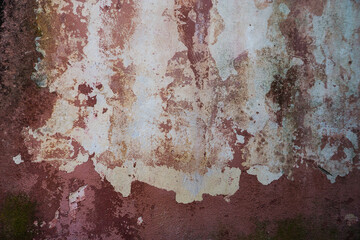 Multi-colored cracked textured plaster on an old wall.