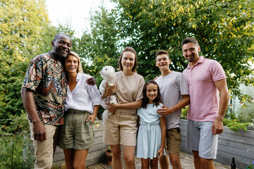 Pleased couple and family with dog posing and looking at camera