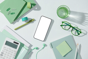 Modern office desk table with paper notebook, pen, smartphone