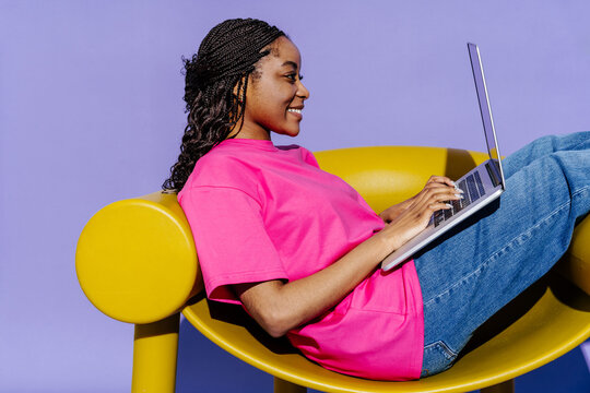Woman working on laptop, vibrant workspace, productive day