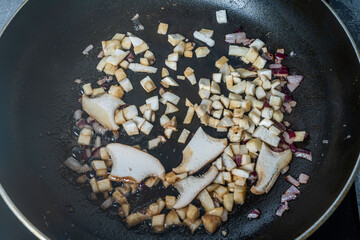 Eringi mushrooms fried with onions in a frying pan