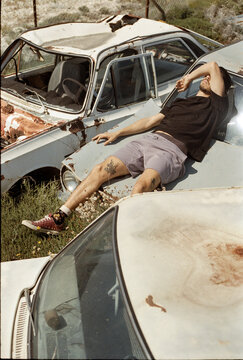 A man laying on the old trash cars