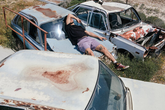 A man laying on the old trash cars