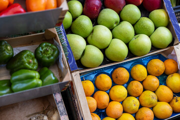 A colorful assortment of fresh fruits fills the crates at a lively market. Enthusiastic shoppers...