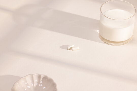 Calcium Supplements Next to a Glass of Milk 