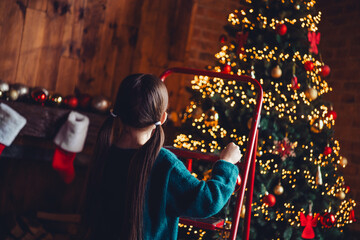 Photo of nice little girl ladder decorate tree wear green christmas clothes enjoy cozy x-mas party decoration interior flat indoors