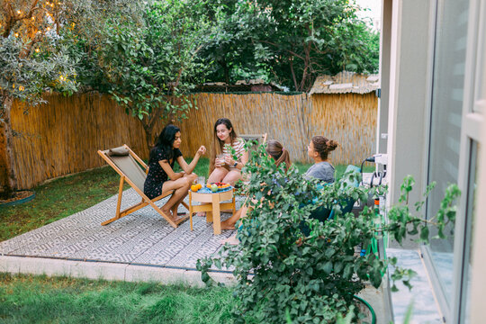 Dinner party of four best girl friends at the backyard in summer