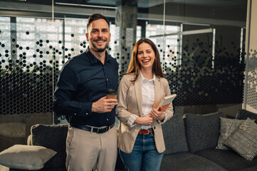 Professional managers standing at corporate office and smiling at camera