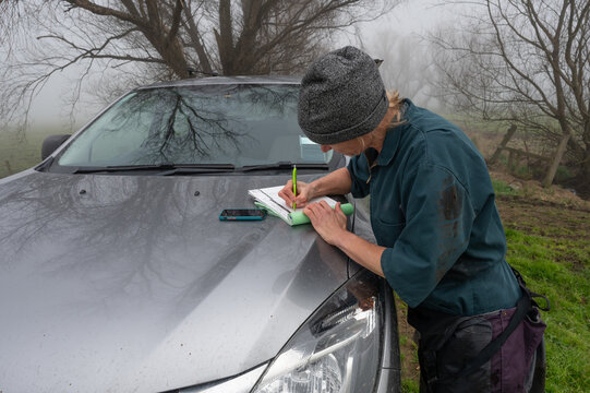 Veterinarian writing docket of farm visit