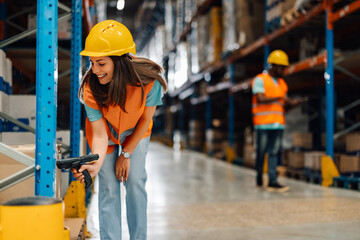 Female warehouse worker scanning barcodes on boxes using scanner