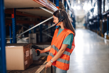 Warehouse worker scanning package and using headset