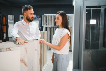 Woman choosing tiles in ceramic and furniture modern shop for her house