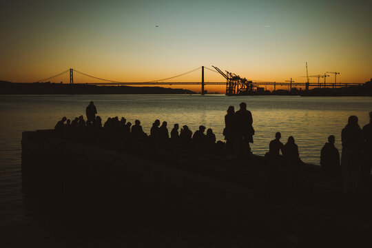 Silhouetted Crowd by the Water at Sunset in Lisbon, Portugal