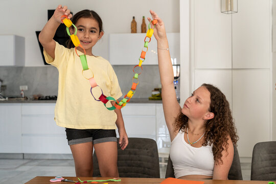 Children Showing Paper Chain Craft At Home