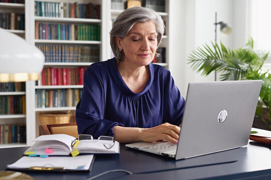 Senior Woman Working on Laptop in Cozy Home Office