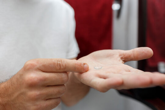 Crop of Man's hand holding contact lens
