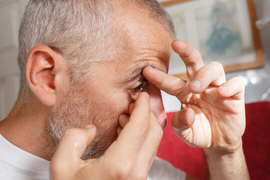 Crop of Man putting contact lenses